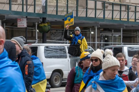 Foto de El alcalde Adams hace comentarios en la ceremonia de izamiento de la bandera para Ucrania. 24 de febrero de 2024, Nueva York, Nueva York, Estados Unidos: Un hombre sostiene una pancarta en una ceremonia de izamiento de la bandera para Ucrania en el segundo aniversario de la invasión rusa de Ucrania - Imagen libre de derechos