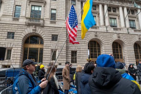 Téléchargez les photos : Le maire Adams prononce un discours lors de la cérémonie de levée de drapeau pour l'Ukraine. 24 février 2024, New York, New York, États-Unis : Un homme tient les étoiles et les rayures et les drapeaux ukrainiens lors d'une cérémonie de levée de drapeau pour l'Ukraine - en image libre de droit