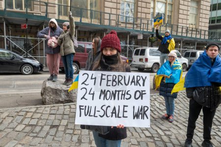 Photo for Mayor Adams Delivers Remarks At Flag-Raising Ceremony For Ukraine. February 24, 2024, New York, New York, USA: A woman holds a 24 FEBRUARY 24 MONTHS OF FULL-SCALE WAR sign at a Flag-Raising Ceremony for Ukraine - Royalty Free Image