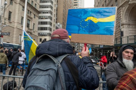 Téléchargez les photos : Le maire Adams prononce un discours lors de la cérémonie de levée de drapeau pour l'Ukraine. 24 février 2024, New York, New York, USA : Un homme tient une pancarte lors d'une cérémonie de levée de drapeau pour l'Ukraine à l'occasion du deuxième anniversaire de l'invasion russe de l'Ukraine - en image libre de droit