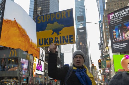 Téléchargez les photos : Guerre Russie-Ukraine : 2e anniversaire de l'invasion à grande échelle de la Russie. 24 février 2024, New York, New York, États-Unis : Un homme signe SUPPORT UKRAINE lors d'un rassemblement pour l'Ukraine à l'occasion du deuxième anniversaire de l'invasion russe de l'Ukraine - en image libre de droit