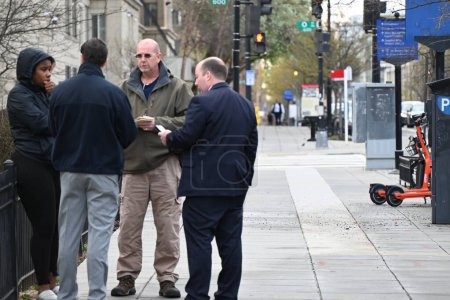 Téléchargez les photos : Les inspecteurs sont à la recherche d'indices et parlent aux piétons alors qu'ils continuent d'enquêter sur une fusillade qui a fait sept morts et deux morts, tôt le matin de la Saint-Patrick à Washington, DC dimanche. - en image libre de droit