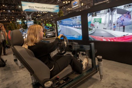 Photo for The New York International Auto Show 2024. March 27, 2024, New York, New York, USA: Women use the Volkswagen ID.4 ride simulator during the International Auto Show press preview at the Jacob Javits Convention Center on March 27, 2024 - Royalty Free Image