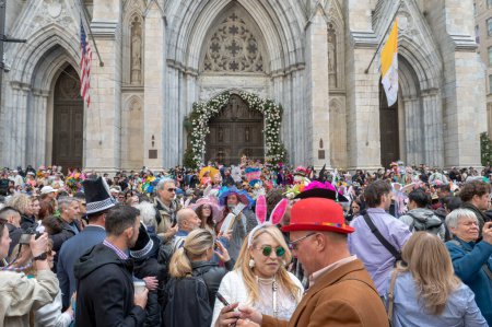 Téléchargez les photos : Parade du Bonnet de Pâques. 31 mars 2024, New York, New York, États-Unis : Des gens portant des costumes et des chapeaux richement décorés s'entassant sur les marches de la cathédrale Saint-Patrick pendant le défilé de Pâques - en image libre de droit