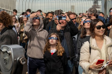 Téléchargez les photos : Solar Eclipse 2024 à New York. 08 avril 2024, New York, New York, USA : Les gens regardent une éclipse solaire partielle depuis le pont d'observation du 86ème étage de l'Empire State Building le 8 avril 2024 à New York. Avec la première éclipse solaire - en image libre de droit