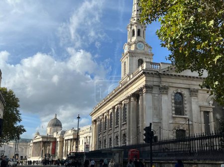 Téléchargez les photos : Londres, Angleterre, Royaume-Uni - 26 octobre 2022 : vue sur le paysage depuis Charing Cross de St Martin dans les champs célèbre église avec la National Gallery à Trafalgar Square en arrière-plan ciel bleu et verdure - en image libre de droit