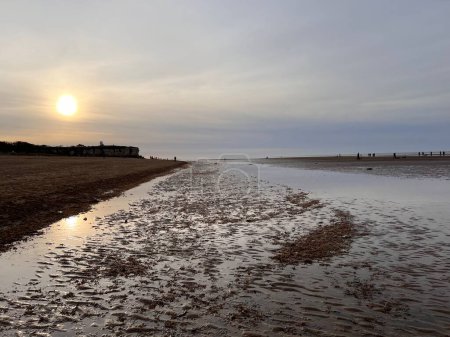 Téléchargez les photos : Beau paysage de plage de coucher de soleil à la plage de sable jurassique falaise à Hunstanton Norfolk uk en début de soirée lumière avec ciel coloré reflété dans l'eau de mer océan sur le rivage environnement paisible - en image libre de droit