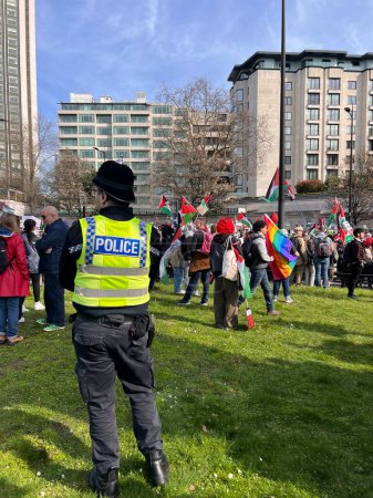 Photo for London, England, UK - March 9 2024: Police guarding peaceful anti- war coalition protest from Hyde Park to US embassy for ceasefire in Gaza Middle East groups include Muslims Jews Christians marching with colourful  flags banners by Wellington arch - Royalty Free Image