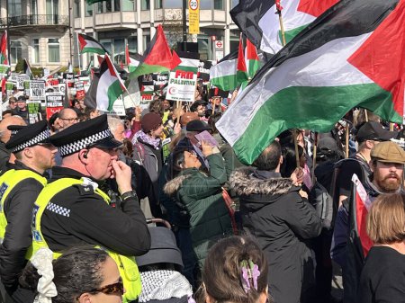 Photo for London, England, UK - March 9 2024: Peaceful anti- war coalition protest for ceasefire in Middle East from Hyde Park to US embassy groups include Muslims Jews Christians marching and chanting with flags and banners - Royalty Free Image