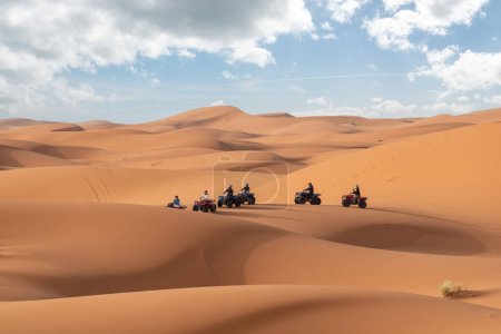 Foto de Motociclistas conduciendo todoterreno en el desierto de Erg Chebbi cerca de Merzouga, Marruecos - Imagen libre de derechos