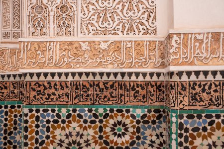 Baldosas orientales tradicionales y estuco caligráfico en una pared de una madraza, Marruecos