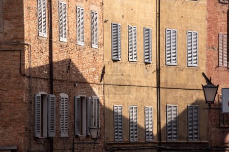 Photo for Houses in downtown Siena with closed window shutters, Italy - Royalty Free Image