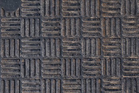 Close up black metal grate in woven squares pattern. Background and wallpaper texture