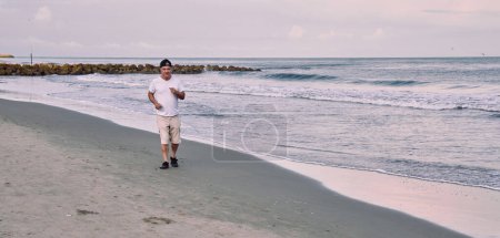 Homme plus âgé marchant sur la plage au bord de la mer à Cartagena de Indias, Colombie.