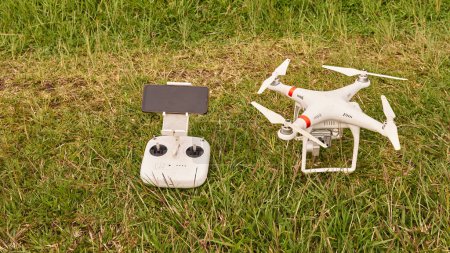 Drohne und Steuerung, auf dem Rasen bereit für die Arbeit gezeigt. Kartographische Arbeit. Luftaufnahmen.