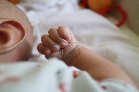 Foto de A photo of one hand of a newborn in a grasping position with the thumb inside - Imagen libre de derechos