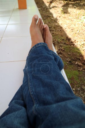 Téléchargez les photos : Une photo d'une paire de jambes d'un homme portant un pantalon bleu avec un sol en céramique en arrière-plan - en image libre de droit