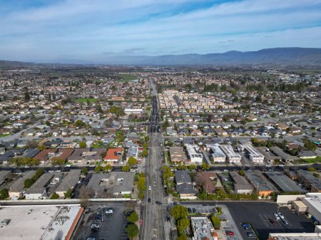 Photo for Aerial photos over a suburb in Gilroy, California with a blue sky and houses, roads and parks with room for text on the top - Royalty Free Image