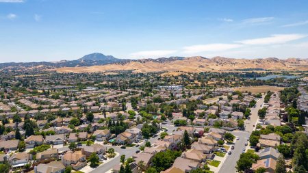 Foto de Imágenes aéreas sobre una comunidad en Antioquía, California con casas, autos, calles y árboles. Con un cielo azul y espacio para el texto - Imagen libre de derechos