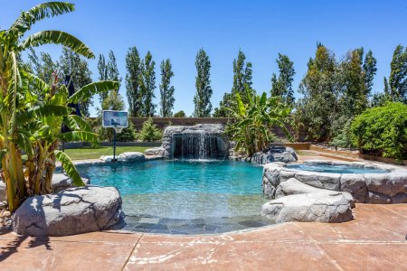 ein großer Pool mit blauem Wasser umgeben von Bäumen an einem schönen sonnigen Tag