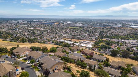 Aerial images over a neighborhood in Hayward, California with a blue sky and room for text. 