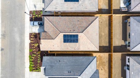 Foto de Vista de arriba hacia abajo de una casa con un panel solar y un patio trasero vacío - Imagen libre de derechos
