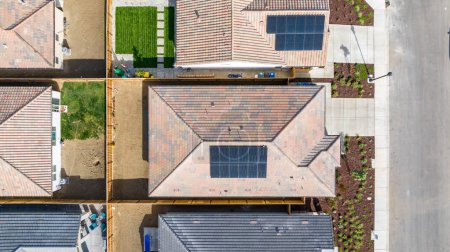 Téléchargez les photos : Vue du haut vers le bas d'une maison avec un panneau solaire dessus et une cour arrière vide - en image libre de droit
