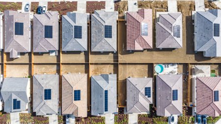Foto de Vista de arriba hacia abajo de una fila de casas residenciales con paneles solares en el techo - Imagen libre de derechos