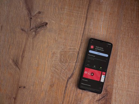 Foto de Lod, Israel - July 16,2023: Twilio Authy Authenticator app play store page on smartphone on wooden background. Top view flat lay with copy space. - Imagen libre de derechos