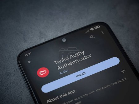 Foto de Lod, Israel - July 16,2023: Twilio Authy Authenticator app play store page on smartphone on a dark marble stone background. Top view flat lay with copy space. - Imagen libre de derechos