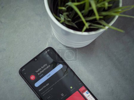 Foto de Lod, Israel - July 16,2023: Modern workspace with smartphone with Twilio Authy Authenticator app play store page on marble background. Close up top view flat lay. - Imagen libre de derechos