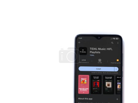 Foto de Lod, Israel - July 16,2023: TIDAL Music app play store page on smartphone on white background. Top view flat lay with copy space. - Imagen libre de derechos