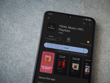 Foto de Lod, Israel - July 16,2023: TIDAL Music app play store page on smartphone on ceramic stone background. Top view flat lay with copy space. - Imagen libre de derechos