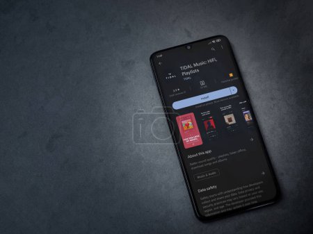 Foto de Lod, Israel - July 16,2023: TIDAL Music app play store page on smartphone on a dark marble stone background. Top view flat lay with copy space. - Imagen libre de derechos