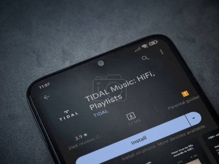 Foto de Lod, Israel - July 16,2023: TIDAL Music app play store page on smartphone on a dark marble stone background. Top view flat lay with copy space. - Imagen libre de derechos