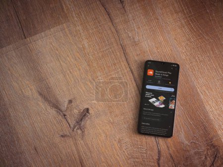 Foto de Lod, Israel - July 16,2023: SoundCloud app play store page on smartphone on wooden background. Top view flat lay with copy space. - Imagen libre de derechos