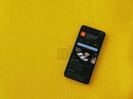 Foto de Lod, Israel - July 16,2023: SoundCloud app play store page on smartphone on a yellow fabric background. Top view flat lay with copy space. - Imagen libre de derechos