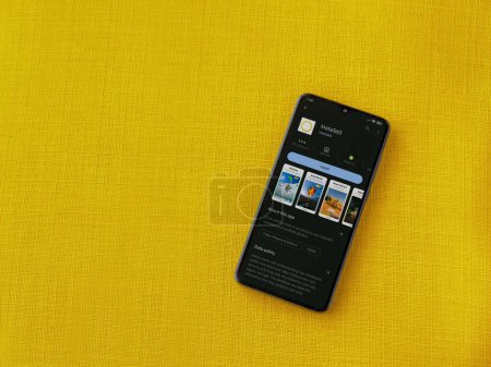 Photo for Lod, Israel - July 16,2023: Insta360 app play store page on smartphone on a yellow fabric background.. Top view flat lay with copy space. - Royalty Free Image