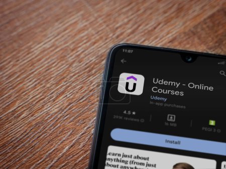 Foto de Lod, Israel - July 16,2023: Udemy app play store page on smartphone on wooden background. Top view flat lay with copy space. - Imagen libre de derechos
