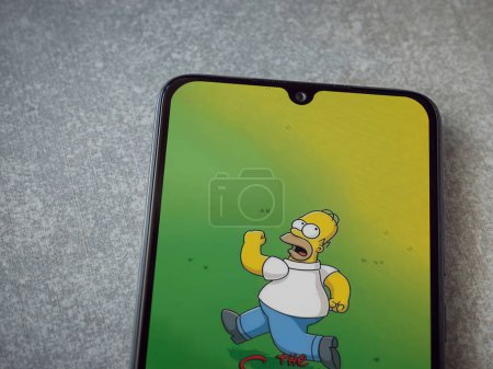 Photo for Lod, Israel - July 16,2023: The Simpsons Tapped Out app launch screen on smartphone on ceramic stone background. Top view flat lay with copy space. - Royalty Free Image