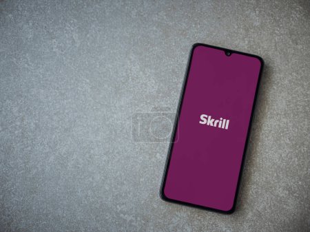 Photo for Lod, Israel - July 16,2023: Skrill app launch screen on smartphone on ceramic stone background. Top view flat lay with copy space. - Royalty Free Image