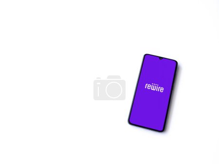 Photo for Lod, Israel - July 16,2023: Rewire app launch screen on smartphone on white background. Top view flat lay with copy space. - Royalty Free Image