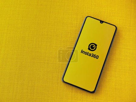Photo for Lod, Israel - July 16,2023: Insta360 app launch screen on smartphone on yellow fabric background. Top view flat lay with copy space. - Royalty Free Image