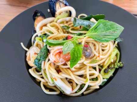 Photo for Drunken seafood spaghetti in a black plate. - Royalty Free Image