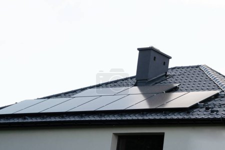 Installing a Solar Cell on a Roof. Solar panels on roof. Historic farm house with modern solar panels on roof and wall. High quality photo