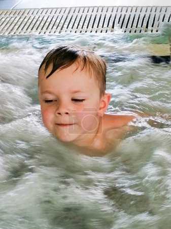 Photo for Pretty little boy swimming in outdoor pool and have a fun with inflatable circle. Adorable brother and sister siblings playing in swimming pool on vacation High quality photo - Royalty Free Image