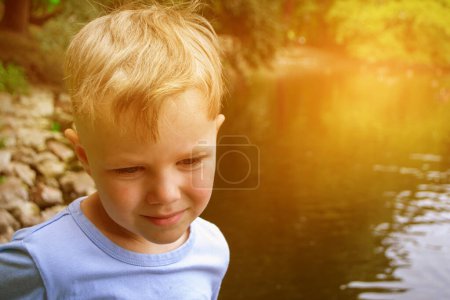 schöner Teenager-Junge lässt Drachen auf dem Meer in blauem Himmel steigen, aus nächster Nähe. Hochwertiges Foto