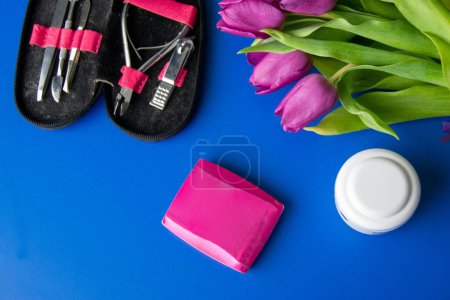 Tools and cosmetics needed for nail styling on a blue background. Pedicure set isolated on white. pink cosmetic bag and a set of women's accessories. High quality photo