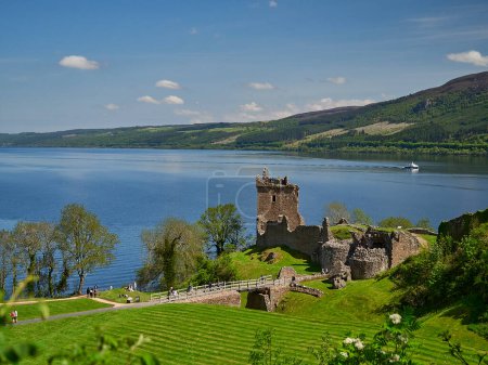 Photo for Drumnadrochit, Scotland - 05 23 2018: Urquhart Castle located on the banks of Loch Ness, Scotland on a clear sunny day with blue sky. - Royalty Free Image
