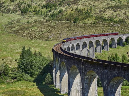 Téléchargez les photos : Glenfinnan, Écosse - 29 05 2018 : train à vapeur jacobite emblématique traversant le viaduc de Glenfinnan dans les hautes terres écossaises. - en image libre de droit